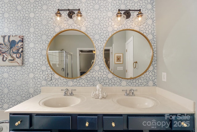 full bathroom with double vanity, wallpapered walls, and a sink