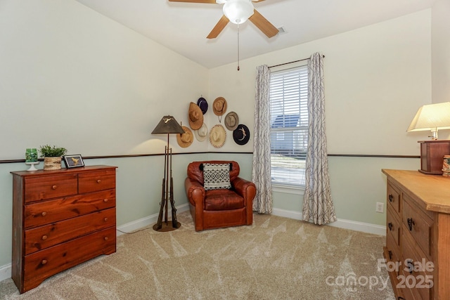 living area with ceiling fan, carpet, and baseboards