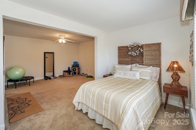 carpeted bedroom with ceiling fan and baseboards