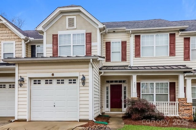 multi unit property featuring concrete driveway, an attached garage, a standing seam roof, and metal roof