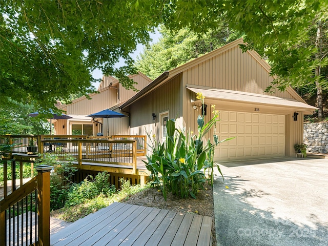 view of front facade featuring a garage, concrete driveway, and a deck