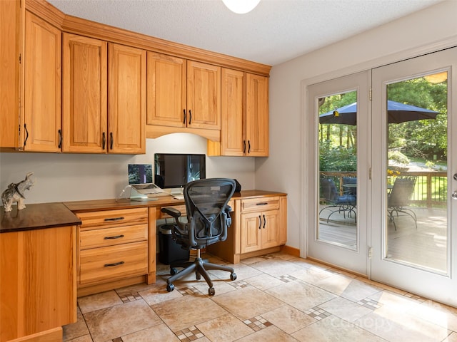 office featuring a textured ceiling and built in desk