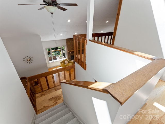 stairway with wood finished floors, a ceiling fan, and recessed lighting