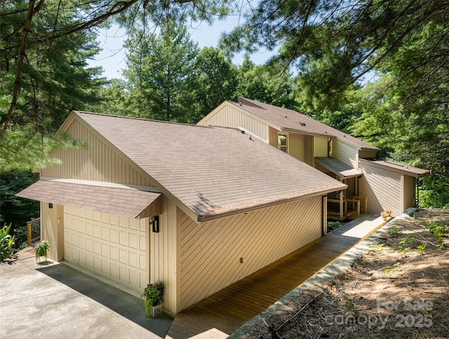 exterior space featuring roof with shingles and an attached garage