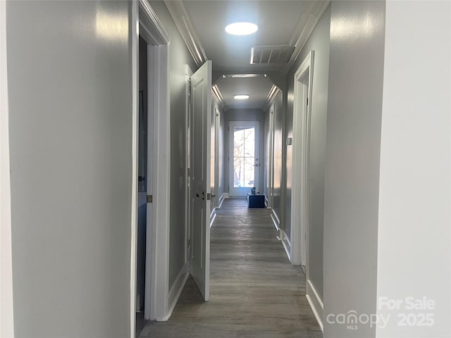 corridor featuring baseboards, visible vents, and dark wood-style flooring