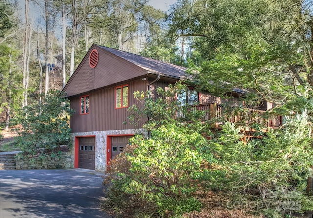 view of side of home featuring driveway and an attached garage