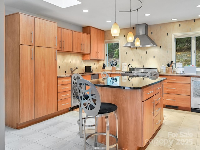 kitchen with a breakfast bar, a sink, a kitchen island, range hood, and tasteful backsplash