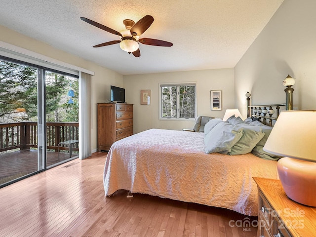 bedroom featuring visible vents, ceiling fan, wood-type flooring, access to outside, and a textured ceiling