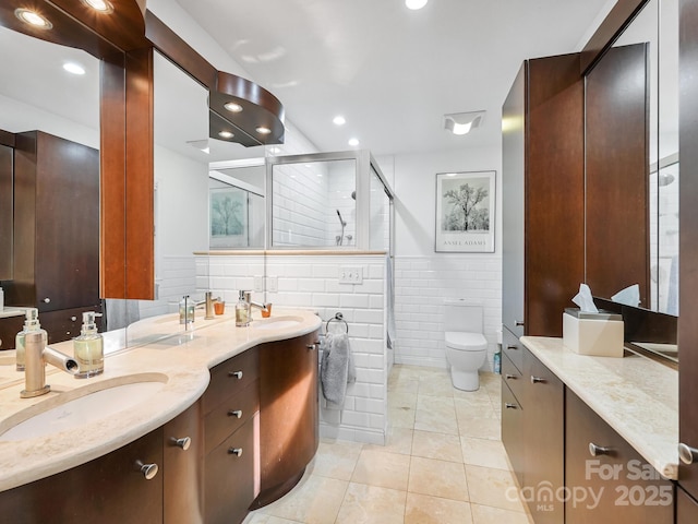 full bath with double vanity, a shower stall, a sink, and tile patterned floors