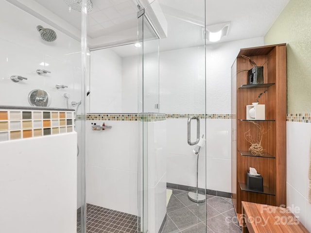 bathroom with a stall shower and tile patterned flooring