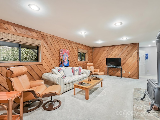 carpeted living area with recessed lighting, a wood stove, and wood walls