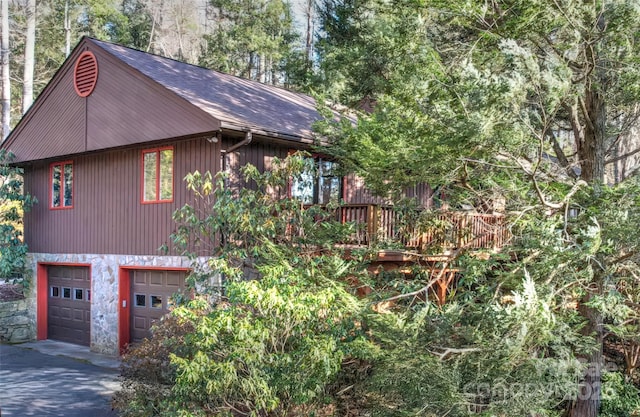 view of property exterior featuring a garage and driveway