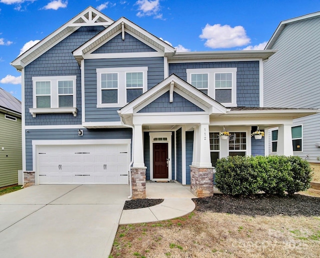 craftsman inspired home featuring concrete driveway, stone siding, and an attached garage