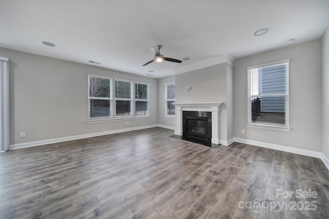 unfurnished living room with visible vents, baseboards, ceiling fan, wood finished floors, and a high end fireplace