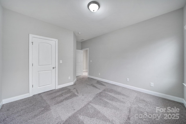 unfurnished bedroom featuring carpet floors and baseboards