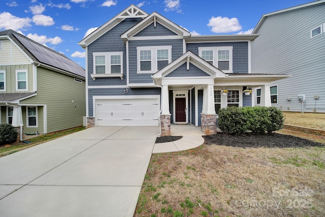 craftsman house featuring a garage, stone siding, and driveway