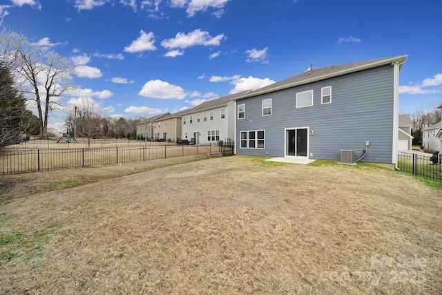 back of house with a patio area, a fenced backyard, a yard, and central air condition unit