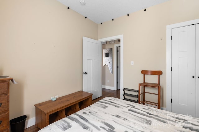 bedroom featuring a closet, baseboards, and wood finished floors