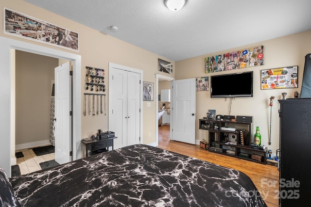 bedroom with a closet, a textured ceiling, and wood finished floors