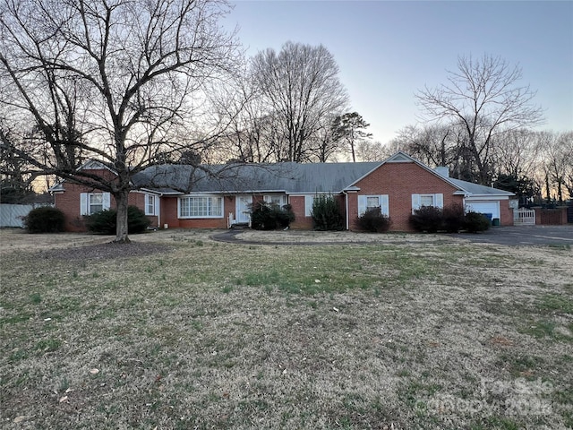 ranch-style home featuring brick siding and a front lawn