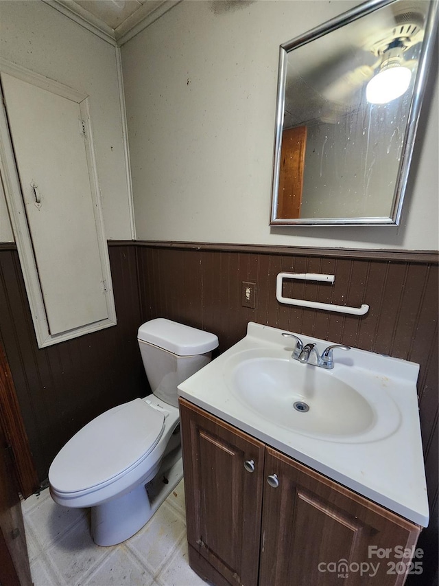 bathroom with wainscoting, vanity, toilet, and tile patterned floors