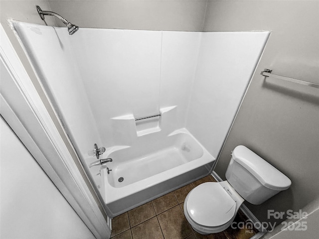 bathroom with toilet, tile patterned flooring, and shower / washtub combination