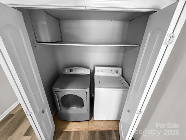 laundry room with laundry area, washing machine and dryer, and wood finished floors