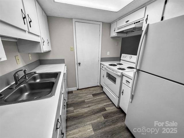 kitchen with dark wood finished floors, white cabinetry, a sink, white appliances, and under cabinet range hood