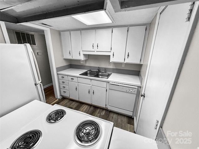 kitchen with white appliances, visible vents, dark wood finished floors, light countertops, and a sink