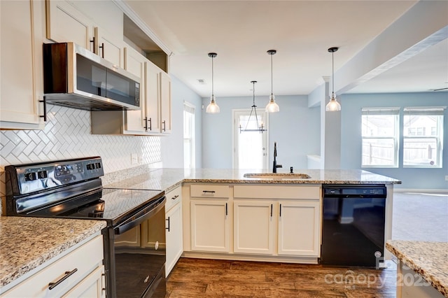 kitchen with black appliances, a sink, plenty of natural light, tasteful backsplash, and a peninsula