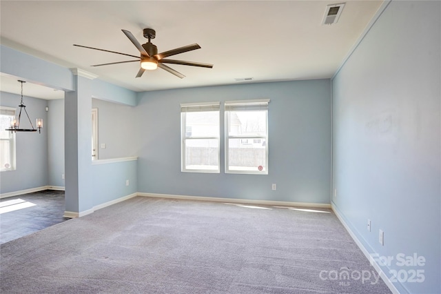 carpeted empty room featuring visible vents, baseboards, and ceiling fan with notable chandelier