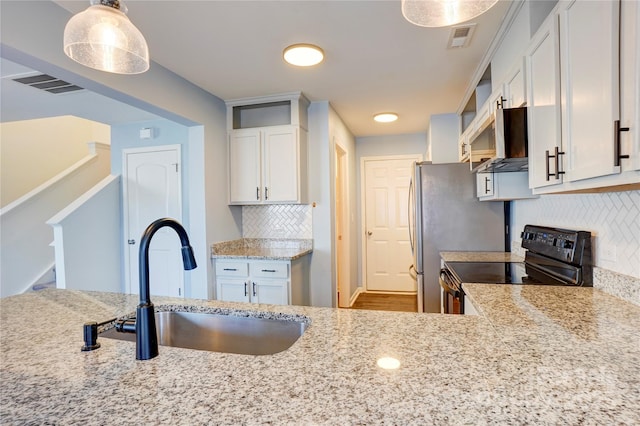 kitchen with black electric range, visible vents, exhaust hood, and a sink