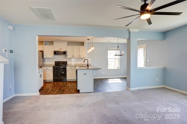 kitchen with visible vents, open floor plan, dark carpet, decorative backsplash, and appliances with stainless steel finishes