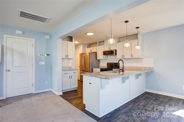 kitchen featuring a breakfast bar area, visible vents, a peninsula, white cabinets, and appliances with stainless steel finishes