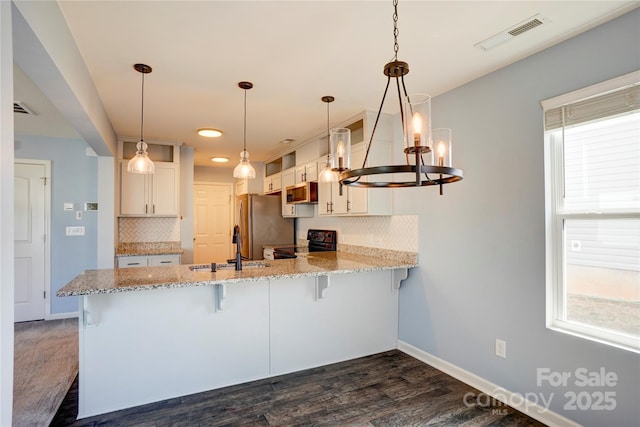 kitchen featuring a peninsula, visible vents, appliances with stainless steel finishes, and a sink