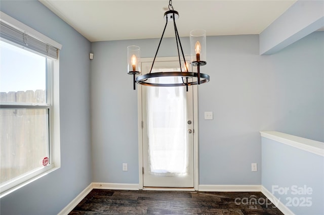 entrance foyer with a notable chandelier, baseboards, and dark wood-style flooring