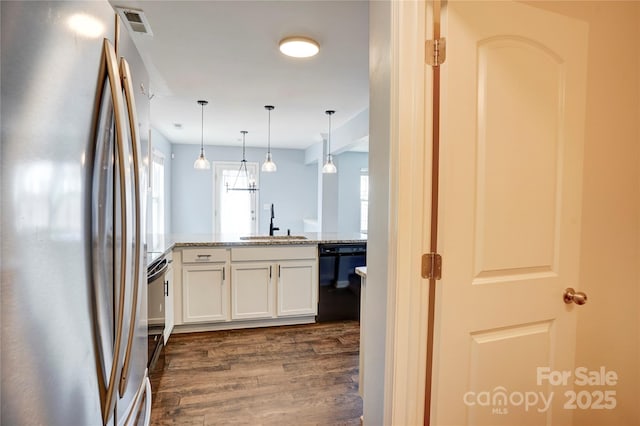 kitchen featuring dishwasher, freestanding refrigerator, dark wood-style floors, white cabinetry, and a sink