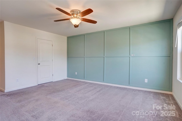 carpeted spare room with baseboards and ceiling fan