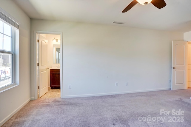 unfurnished room featuring visible vents, light colored carpet, and a healthy amount of sunlight