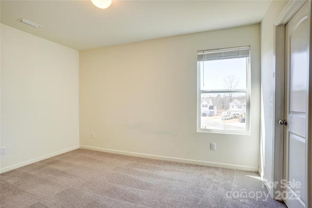 spare room featuring visible vents, carpet floors, and baseboards