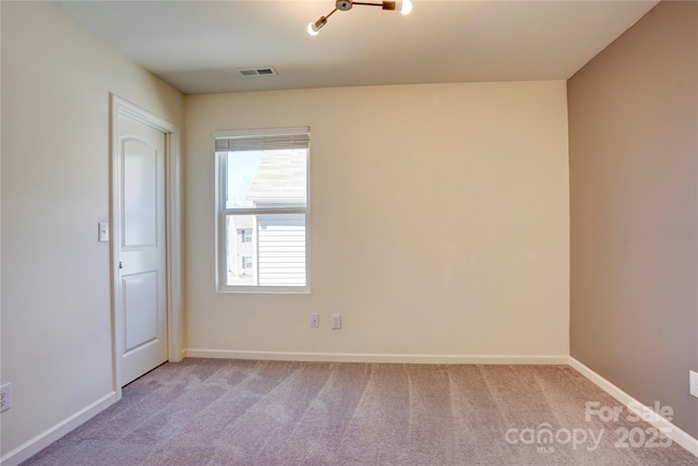 carpeted empty room with visible vents and baseboards