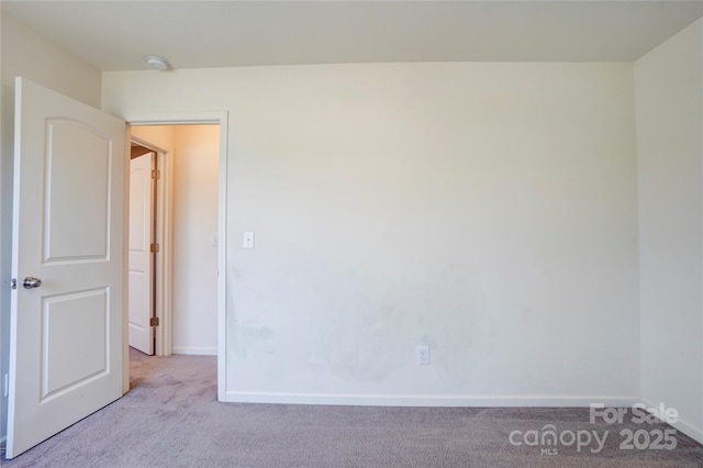 carpeted spare room with baseboards