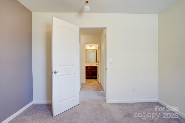 unfurnished bedroom with baseboards and light carpet