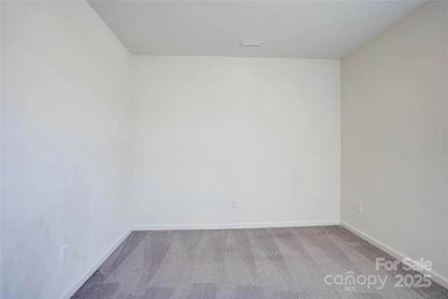 carpeted empty room with visible vents and baseboards