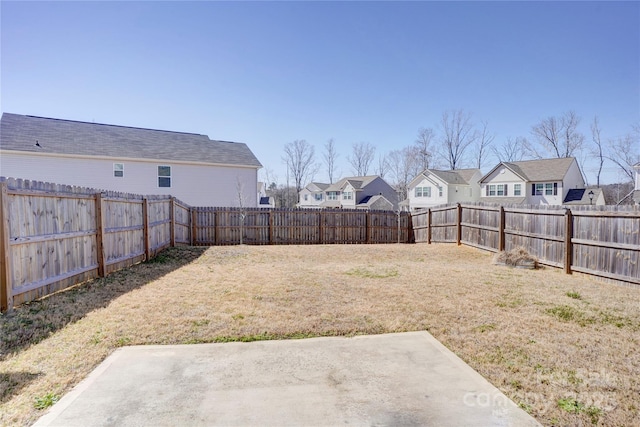 view of yard with a residential view, a patio, and a fenced backyard