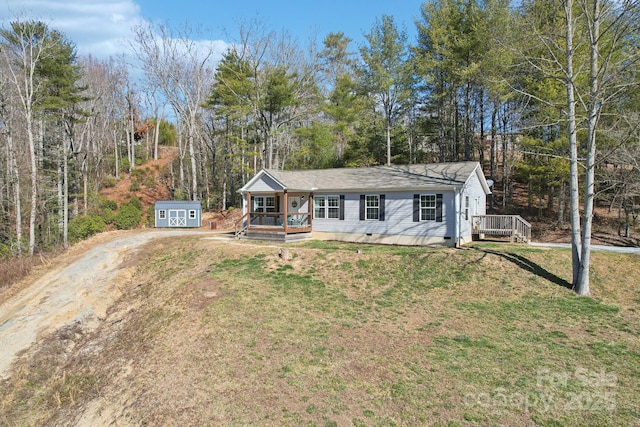 ranch-style home with an outdoor structure, driveway, crawl space, a storage unit, and a front yard