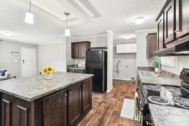 kitchen featuring a center island, decorative light fixtures, range with electric stovetop, freestanding refrigerator, and a sink