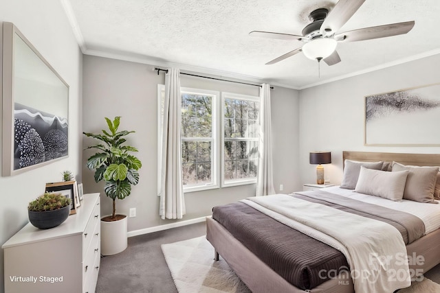 carpeted bedroom featuring ornamental molding, a textured ceiling, baseboards, and a ceiling fan