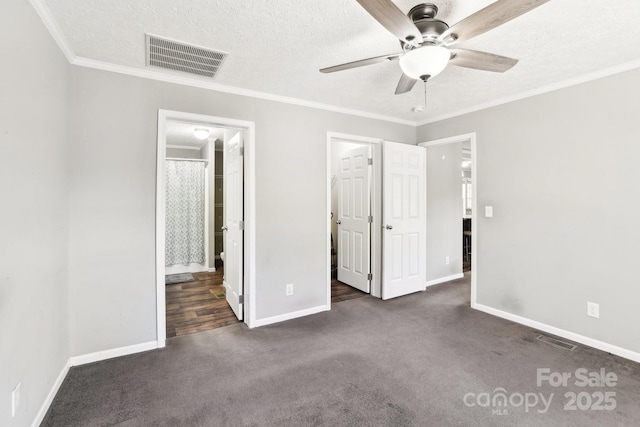 unfurnished bedroom with baseboards, visible vents, ornamental molding, dark colored carpet, and a textured ceiling