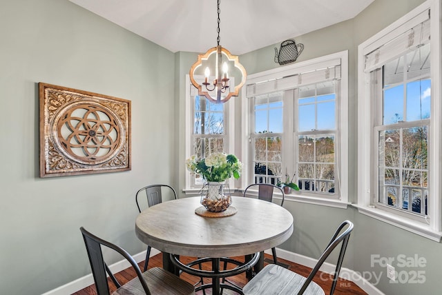 dining room with a notable chandelier, a healthy amount of sunlight, and baseboards